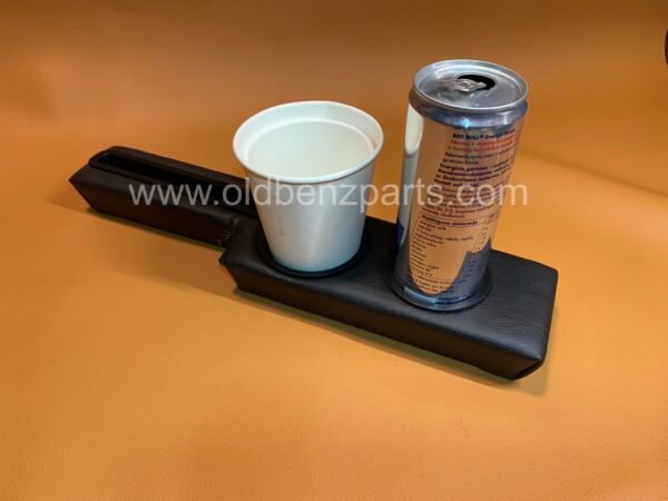 oldbenzpartscom A white ceramic mug and a can of red bull on a black leather tray placed on an orange surface The Mercedes Benz W201 190 Custom Center Console Cup Holder Insert is visible on the tray mercedes benz parts w124 w123 w126 w114 w115